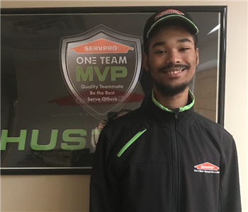 Josiah standing in front of a SERVPRO plaque in our office hallway