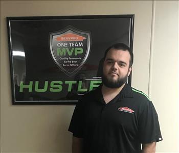 Bryan standing in front of a SERVPRO plaque in our office hallway.